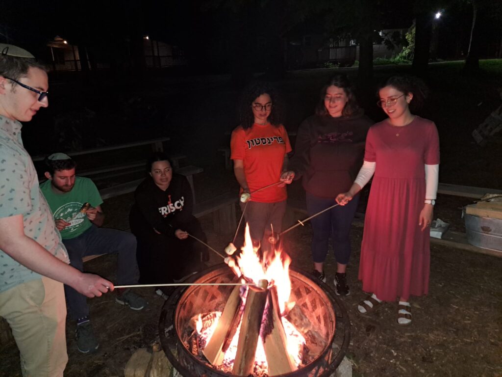 JLIC students roasting marshmallows on an open fire at the Chasidic Retreat.