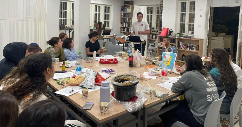 Matthew Levine giving his Mishmar shiur to a group of participants from the Summer volunteer trip.