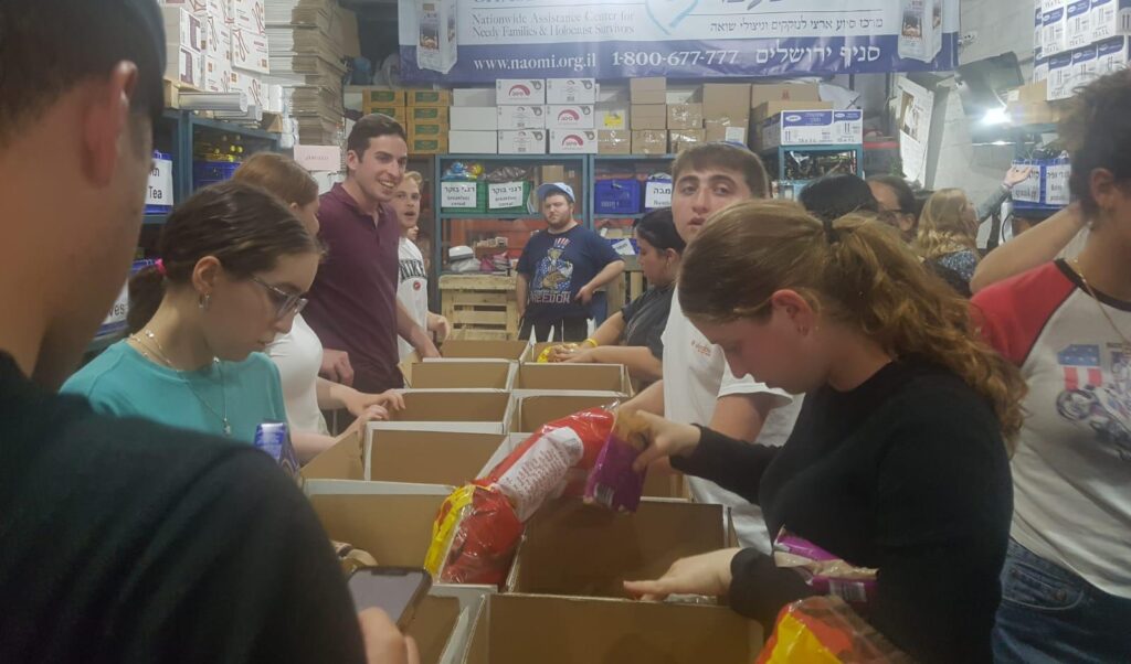 The Summer volunteer group packing food boxes as part of their volunteer activities. 