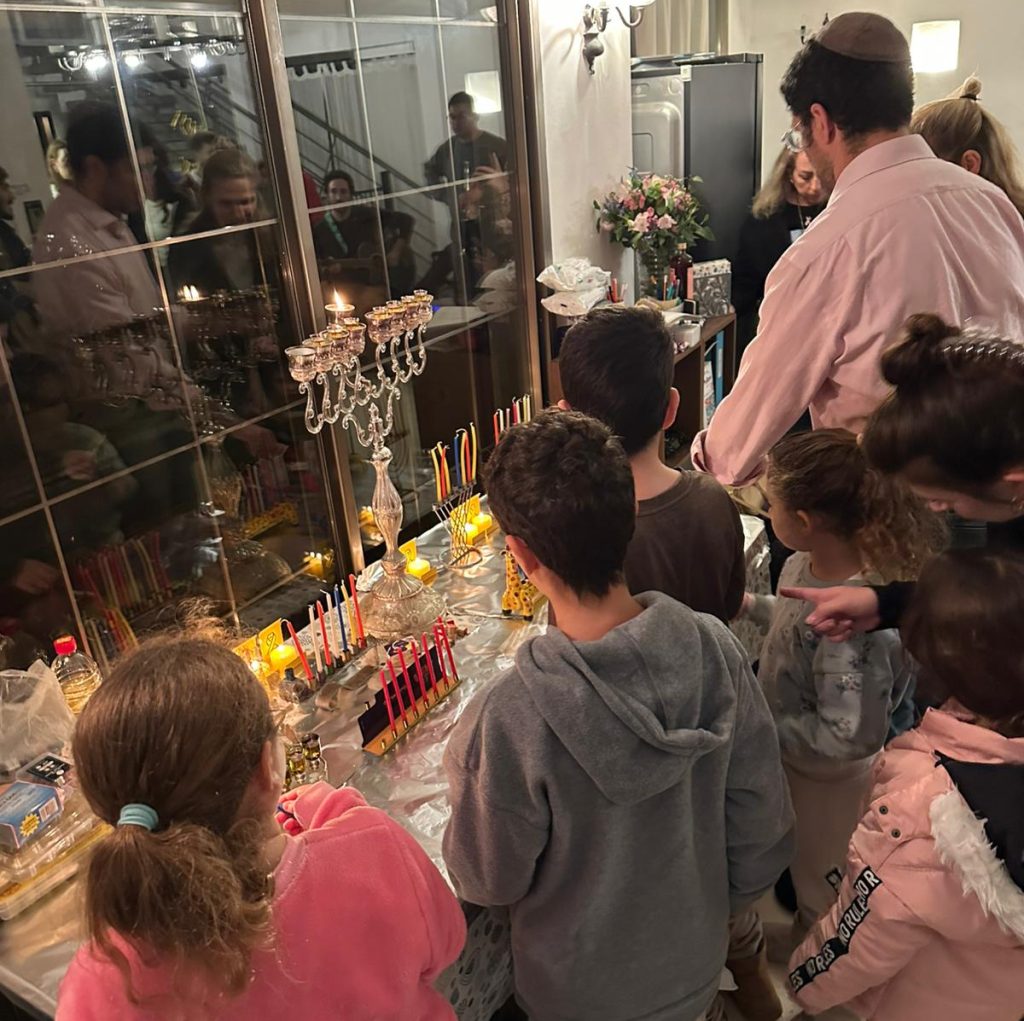 Rabbi Joe Wolfson at his home lighting Chanukah candles with some of the children from the Hostages and Missing Families Forum.