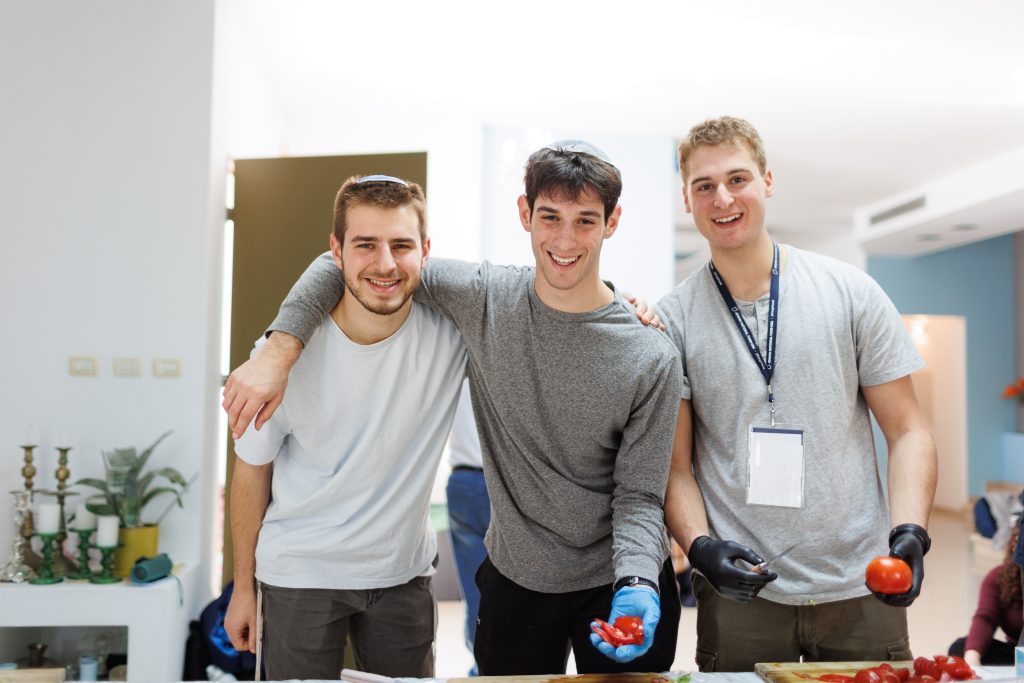 Yavneh Fellows preparing food for less fortunate during one of their volunteer activities during the Alternative Winter Break trip to Israel.