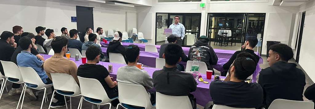 Members of the JLIC Valley Hub listening to Rabbi Kaplan and a Manghal Monday night event